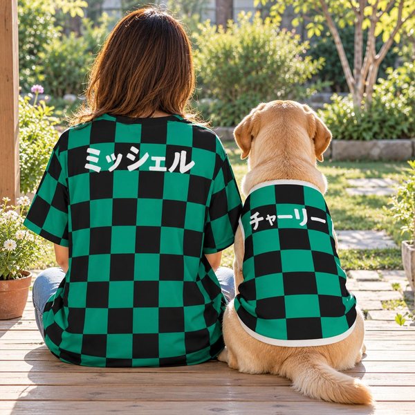 Matching dog and owner shirts seen from behind: a person and a Labrador sit side by side on a wooden porch in the green and black checkerboard design, with the names Michelle and Charlie in Japanese katakana.