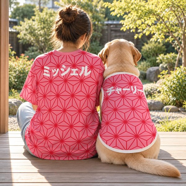 Matching dog and owner shirts seen from behind: a person and a Labrador sit side by side on a wooden porch in the pink asanoha hemp leaf design, with the names Michelle and Charlie in Japanese katakana.